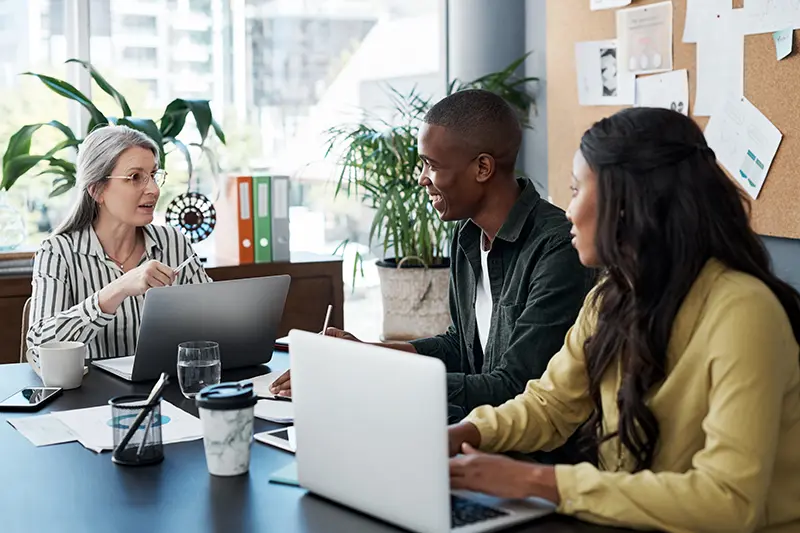 Group of people discussing wealth management while on their laptops